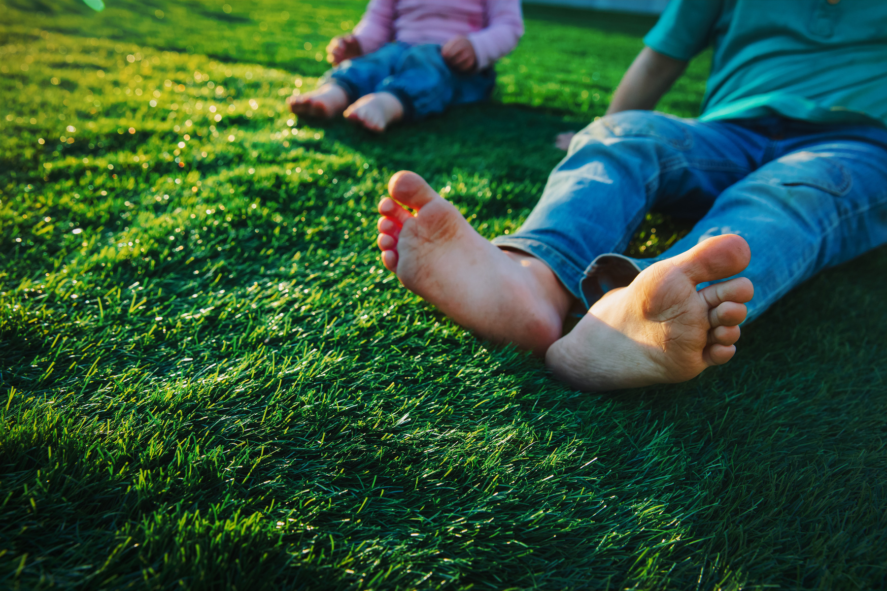 kids play barefoot on grass at sunset nature
